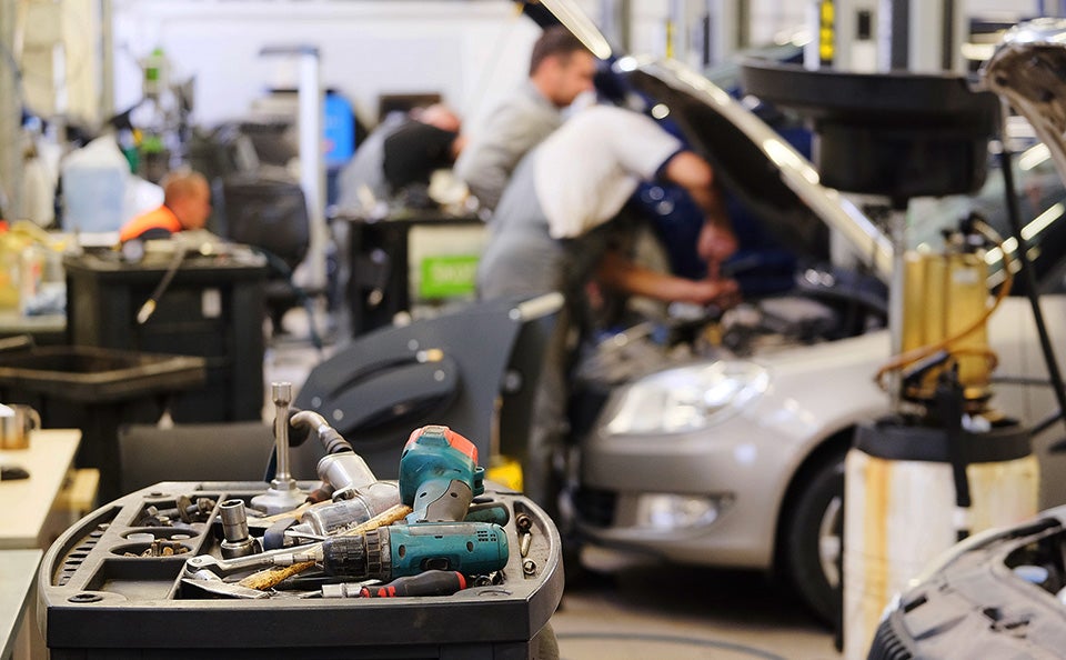 Auto repair shop with mechanics servicing a vehicle.